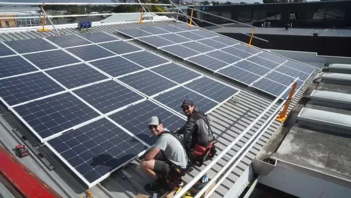 Solar installers fitting panels on a rooftop